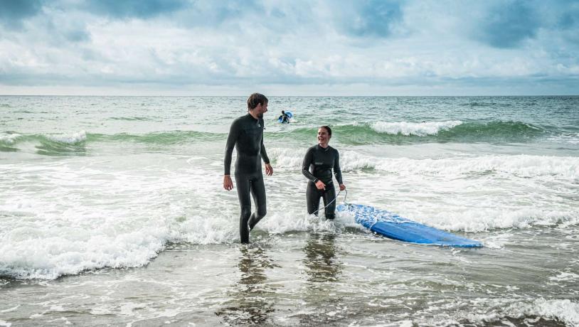 To mennesker der surfer i Vesterhavet 